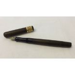 A Mabie Todd 'Swan' fountain pen in brown wave design with ornate gold coloured metal collar.