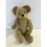 A vintage fully jointed straw filled teddy bear with hump back.