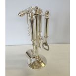 A silver plated stand with 4 bar tools.