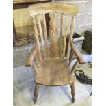 A highback wooden armchair with carved back panel. Approx 111cm tall x 62cm wide.