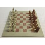 A Kenyan soapstone animal chess set & board. Some pieces a/f.