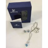 Matching earrings and necklace by Swarovski set with pale blue and clear stones.