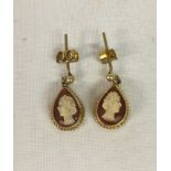 A pair of teardrop shaped cameo earrings set in 9ct gold mounts