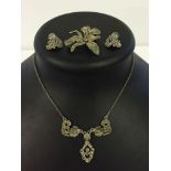 A marcasite necklace together with a brooch and a pair of clip on earrings.