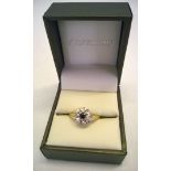 Ladies 18ct gold dress ring set with a central sapphire surrounded by illusion set small diamonds.