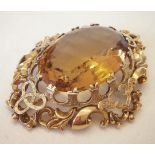 A large ornately mounted yellow quartz brooch, probably citrine. Set in decorative gold mount