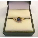 Hallmarked 18ct gold trilogy ring set with a central sapphire approx 0.3ct with diamonds either side