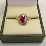 Hallmarked 9ct gold ladies ring with central 0.75ct oval ruby surrounded by clear stones. Size M,