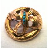 Antique gold brooch designed as a bow within a circle. Centre set with 5 turquoise stones. Weight