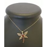 9ct gold hallmarked dragonfly pendant set with diamond eyes and 6 garnets. Approx 2.5cm across x 3cm