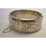 Hallmarked silver hinged bangle with safety chain. Measures 2.5cm wide, weighs approx 40.5g.