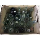 A box of clear and green glass bottles to include vintage milk bottles