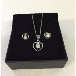A 925 silver heart shaped pendant set with cubic zirconia on chain together with matching earrings.