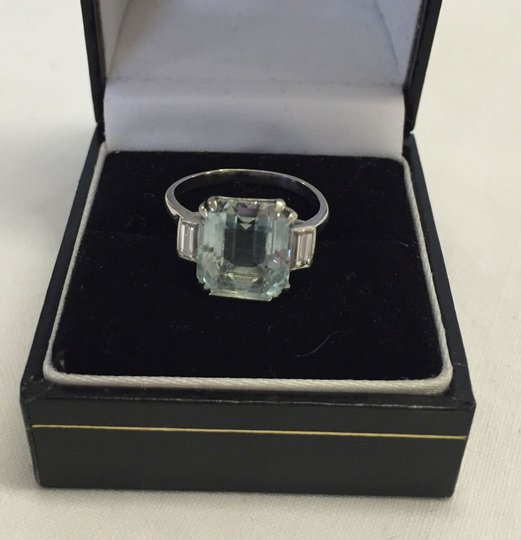 An Art Deco white gold Ring, Set with a large blue topaz stone with bagette diamonds each side. Ring