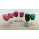 4 cranberry glass glasses together with 3 green glasses