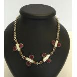 A heavy silver necklace set with 8 large rubies, 8 small garnets and 4 pieces of mabe pearl 20