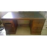 A dark oak pedestal desk with a black top. 4 drawer to one side and 1 drawer to other.