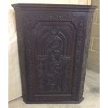A Georgian corner cabinet with internal drawers and Victorian carved front