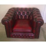 A red leather Chesterfield armchair, some scuffs to front right corner