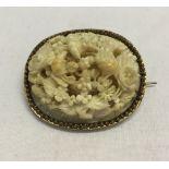 An ornate antique ivory carved brooch of field mice and flowers. 4 x 3.5cm