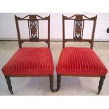 A pair of Edwardian nursing chairs with inlaid marquetry back, red velour upholstery, turned legs on