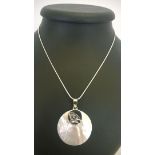 A mother of pearl pendant with a bird motif in 925 silver on a rope chain