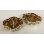 A pair of silver plated coasters with amber effect bases.