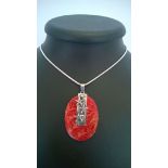 A red coral pendant with a starfish motif in 925 silver on a rope chain