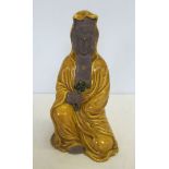 A terracotta oriental diety with yellow glaze finish