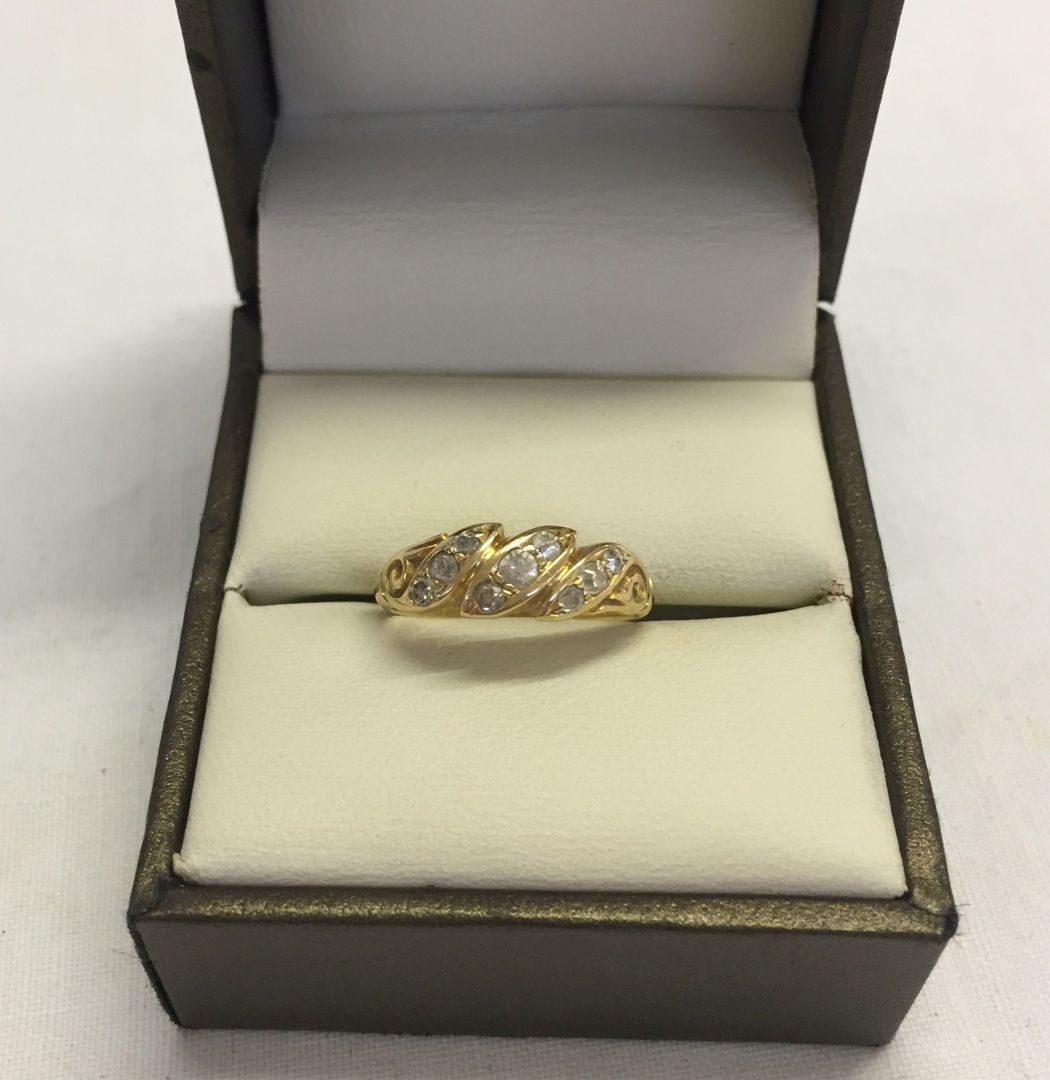 An antique gold and diamond ring set with 9 diamonds, Hallmark rubbed, tests as 18ct gold size J.