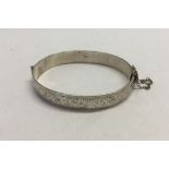A Hallmarked silver bangle, with safety chain. Birmingham 1963. Approx 24.9g