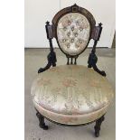 A Victorian black and gilt nursing chair with floral design upholstery. a/f