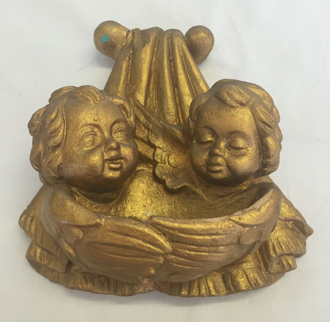 A gold painted cherub plaster wall plaque. a/f repair to top.