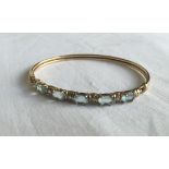 A 9ct gold bangle set with alternating 5 oval blue topaz stones and 4 Cubic Zirconia's. Total weight