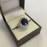 A 14K white gold and diamond ring set with an oval cut blue sapphire approx 5.8ct and diamonds