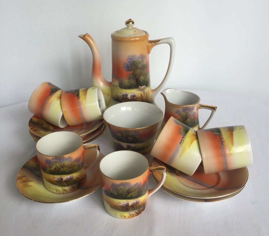 A Noritake coffee set with grazing sheep decoration, comprising; 6 coffee cups & saucers, cream jug,