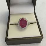 A 14K white gold and diamond ring set with an oval cut ruby approx 5.3ct and diamonds approx 0.