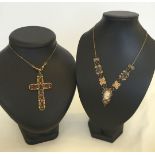2 vintage necklaces. A decorative cross set with coloured stones on a long brass chain together with