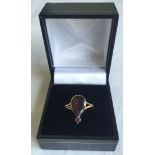 A Victorian gold ring made from a pendant, set with a teardrop garnet and a small round garnet.