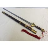 A Japanese sword in red lacquered sheath and brass hilt, pommel & bands.