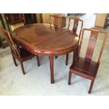 A Chinese solid rosewood circular dining table with extension and four rosewood chairs with