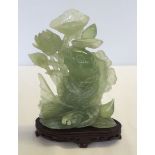 A jade carving of a carp and pond lilies, 21.5cm tall (exc wooden base)