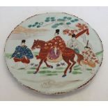 A ceramic oriental plaque depicting travellers. A/F nibbles to outside rim.