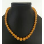 A pressed amber necklace, beads measuring 1.1cm to 0.8cm diameter.