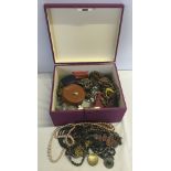 A wooden box of costume jewellery to include necklances, pendants and earring.