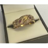A 9ct gold twin headed serpent ring set with two small rubies. Size Y approx weight 7.1g