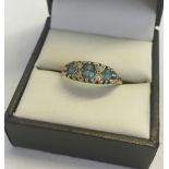 A 9ct gold dress ring set with 3 blue topaz stones and 4 small diamonds. Size S1/2, approx total