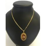 A Copal modern amber oval pendant set in ornate 18ct gold mount on a 14ct gold chain. Total weight