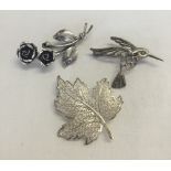 3 silver brooches comprising of a filigree maple leaf, roses and a bird in flight.