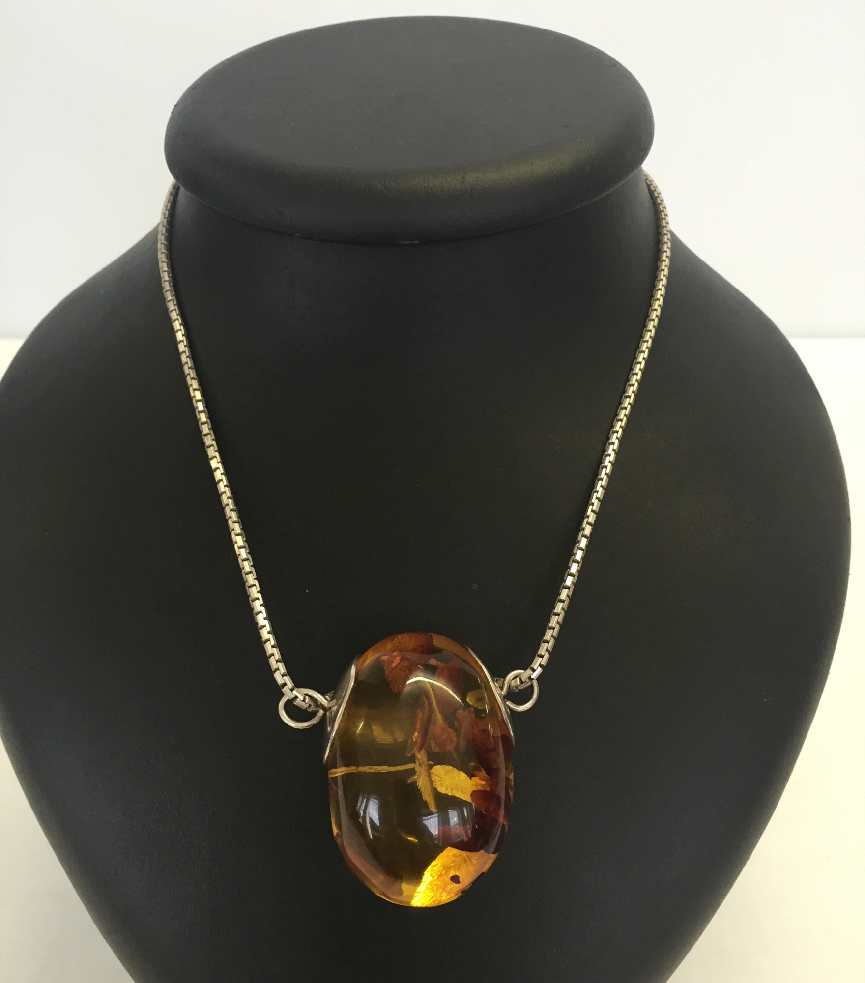 A large Baltic amber egg pendant on a sterling silver chain. Measures 4.5cm x 3cm. Weight of amber